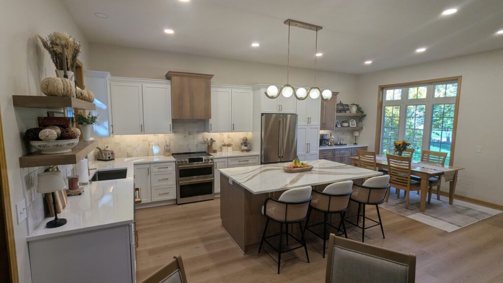 Modern kitchen with white cabinetry, a large island, and an adjacent dining area in Woodbury MN