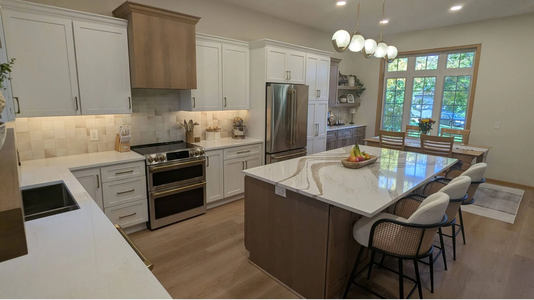 Modern kitchen with white cabinets, quartz island, and stainless steel appliances in Woodbury MN